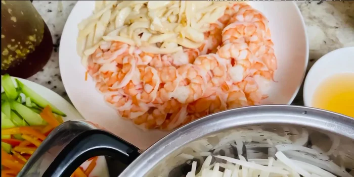 Trộn gỏi: Cho tôm, mực, các loại rau đã cắt vào tô lớn. Thêm nước chấm đã pha vào và trộn đều.