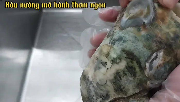 Dùng dao tách nhẹ phần vỏ hàu đã được đập sẵn. Làm sạch kỹ càng bên trong hàu để loại bỏ cát và các mảnh vụn vỏ.