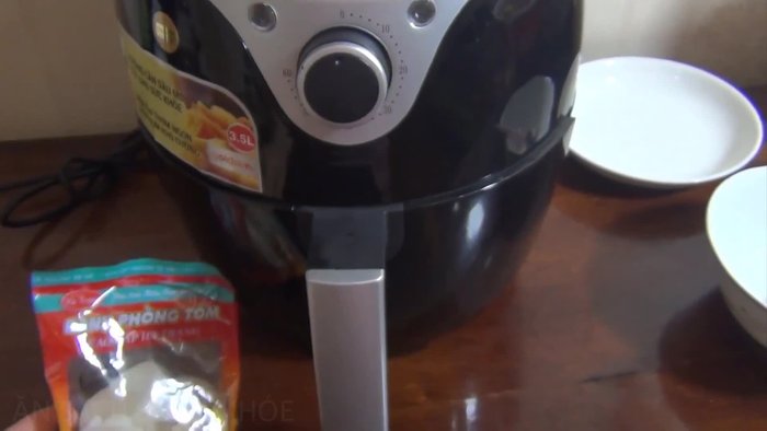 Sắp xếp tôm vào giỏ chiên của nồi chiên không dầu.