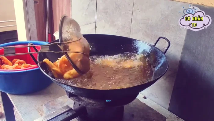 Chiên tôm: Cho một muỗng dầu nghệ vào chảo dầu đang nóng, thả tôm vào chiên đến khi vàng giòn.