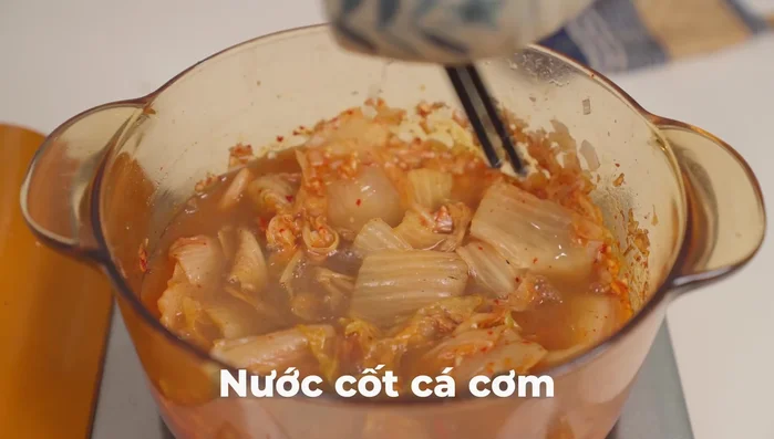 Cho nước cốt cá cơm, nước kim chi, nước lọc vào nồi, nấu sôi. (385.12)
