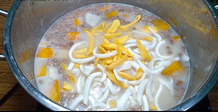 Cho mít và cơm dừa vào, khuấy đều.
