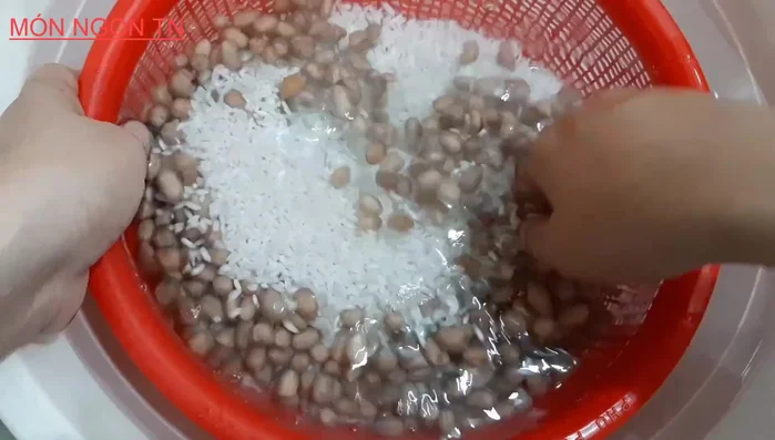 Cho gạo nếp và đậu phộng đã nấu vào nồi cơm điện. Lót lá dứa dưới đáy nồi để chống dính và tạo mùi thơm. (287.36)
