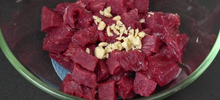 Băm nhỏ 10g tỏi, ướp thịt bò cùng 1 muỗng hạt nêm, 2 muỗng dầu hào, 2 muỗng nước tương, 1 muỗng đường, ½ muỗng ngũ vị hương, chút tiêu, 1 muỗng tương ớt và 1 muỗng dầu ăn. Ướp khoảng 30 phút.