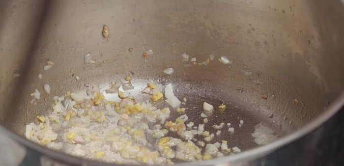 Cho hành, tỏi, gừng còn lại vào phi thơm. Thêm cà chua băm và dứa, đảo đều. Nêm 1 thìa cà phê bột canh.