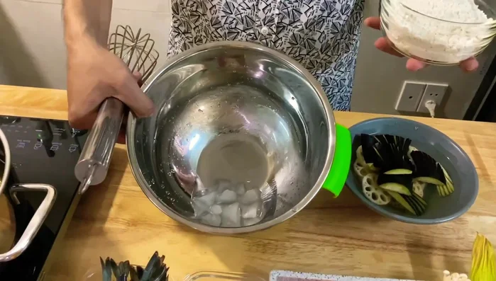Pha bột: Cho nước đá vào bát, sau đó cho nước soda, bột mì, trứng gà, một ít muối vào trộn đều. Đánh nhẹ nhàng để tạo bọt khí giúp tempura giòn.