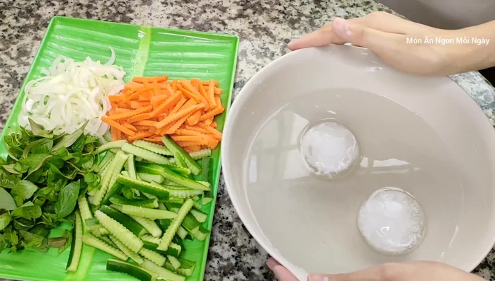 Cắt nhỏ hành tây, cà rốt, dưa leo (bỏ ruột dưa leo). Ngâm các nguyên liệu này trong nước đá lạnh khoảng 15 phút để giảm mùi hăng và tạo độ giòn.