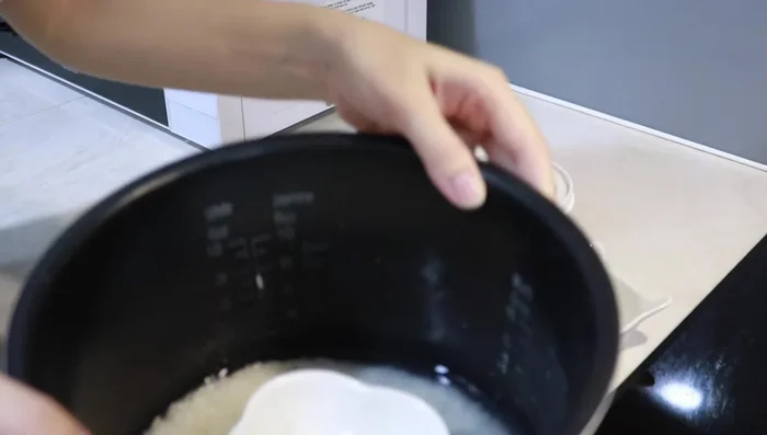 Cho gạo và nước đã đong vào một cốc/chén nhỏ, đặt chung vào nồi cơm điện cùng với gạo nấu cơm gia đình.