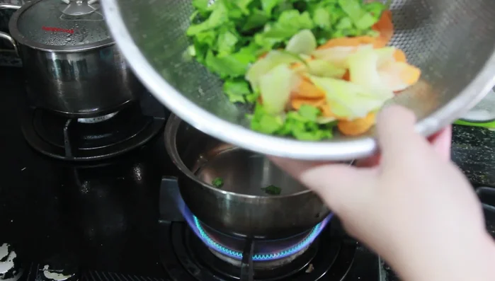 Luộc rau cải ngọt, cà rốt đã bào mỏng (khoảng 5 phút sau khi nước sôi).