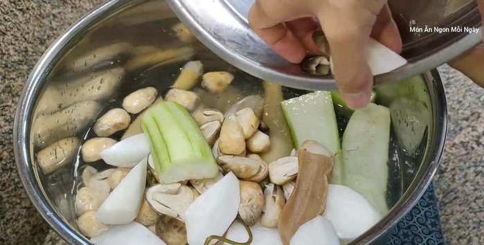 Cho rau củ (củ cải trắng, củ cải muối, nấm rơm, mướp) và mực khô vào.