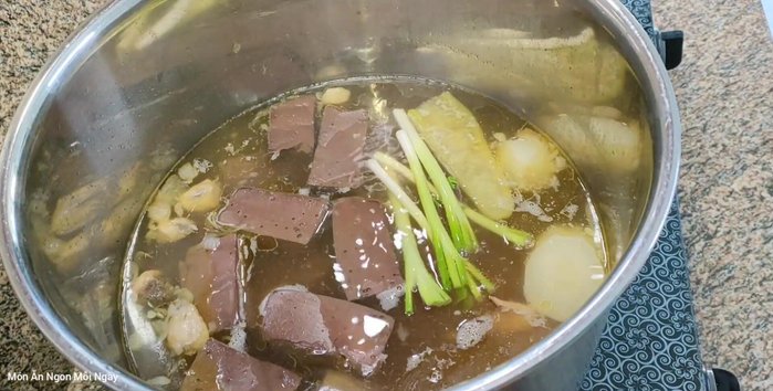 Cho hành lá, ngò rí vào tô bánh canh.
