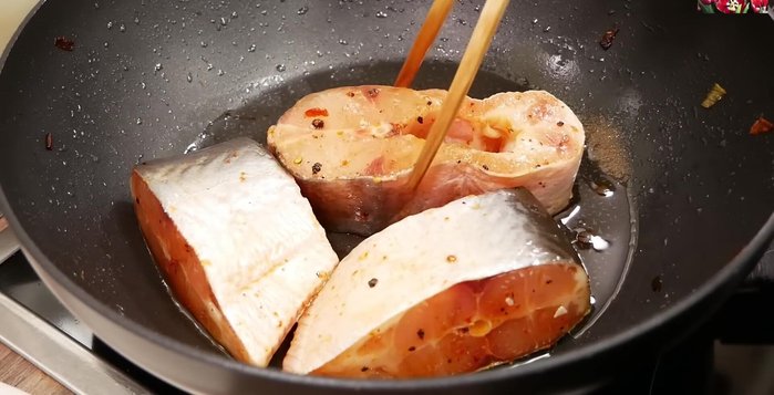 Cho cá vào chảo, xếp đều. Đảo cá cho đến khi da cá săn lại.