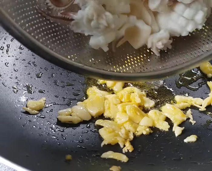 Xào mực: Cho mực vào xào với lửa lớn, liên tục đảo đều để mực áo đều bơ tỏi khoảng 2 phút.