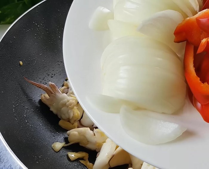 Xào rau củ: Cho hành tây, ớt chuông và hành lá vào xào cùng mực.