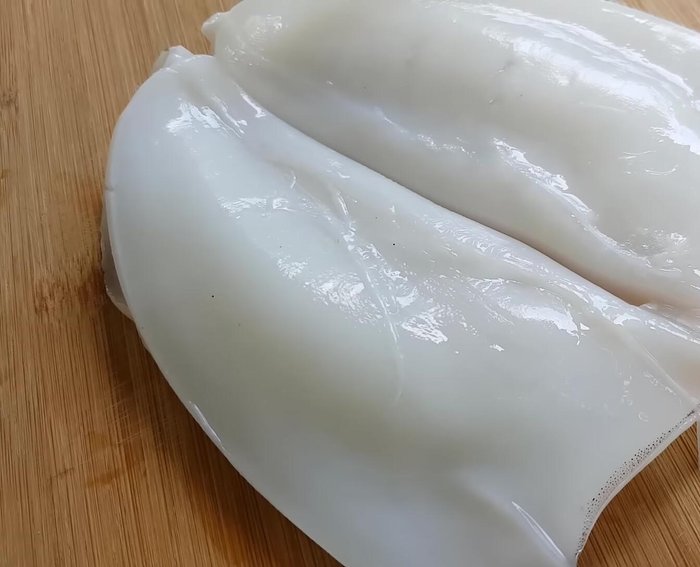 Làm sạch mực: Chẻ đôi mực, lột màng, rửa sạch với nước muối, xả lại với nước và để ráo. Khứa những đường xéo trên thân mực với khoảng cách khoảng 3mm, sau đó khứa xéo ngược lại để tạo hình vuông giúp mực bung ra khi xào, tăng độ hấp dẫn và thấm sốt.
