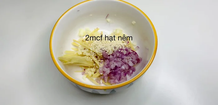Trộn hỗn hợp ướp cá: gừng thái sợi, hành băm, tỏi băm, hạt nêm, muối, bột ngọt, tiêu. Ướp đều lên thân và bụng cá, massage cá khoảng 5-7 phút.