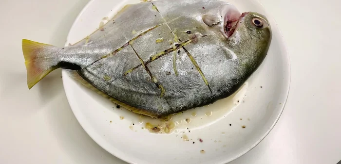Lấy cá ra khỏi tủ lạnh, đặt cá lên giấy bạc, cho hỗn hợp hành, tỏi, nấm mèo đã xào lên trên cá.