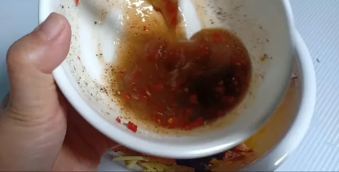 Trộn xoài với nước sốt, thêm hành phi, rau răm, rau quế, khô cá xé nhỏ. Trộn đều.