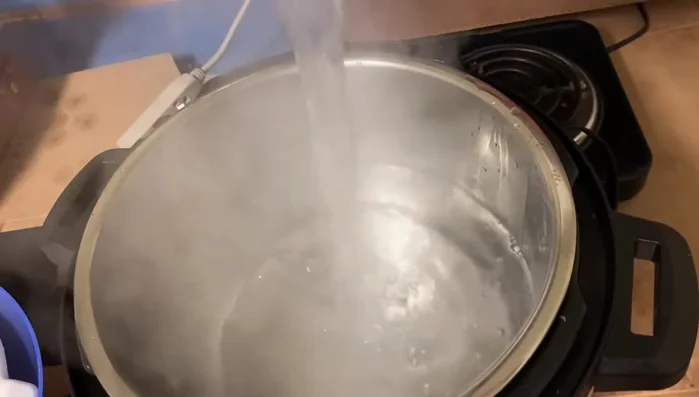 Cho nước vào nồi Instant Pot, thêm sườn, hành tây, hành đỏ, bột nêm, đường phèn, muối. Đun sôi, vớt bọt (225.019).