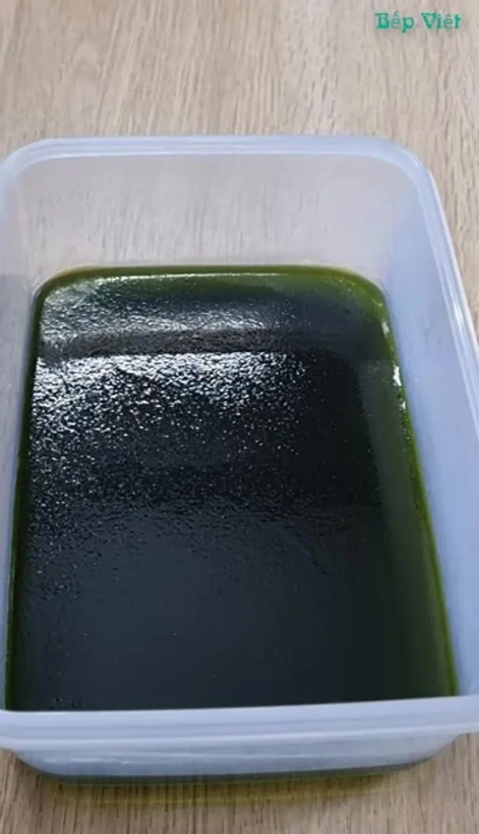 Sau khi lớp rau câu xanh đông lại, đổ lớp rau câu trà sữa lên trên (chia làm 2 phần cho 2 khuôn). Đổ nhẹ tay để tránh làm giỗ mặt lớp dưới.
