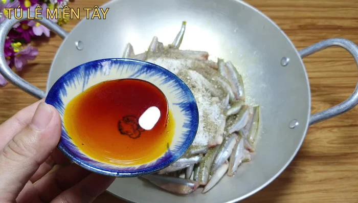 Thêm nước màu (tùy chọn): Cho thêm nước màu tự thắng vào hỗn hợp ướp cá.