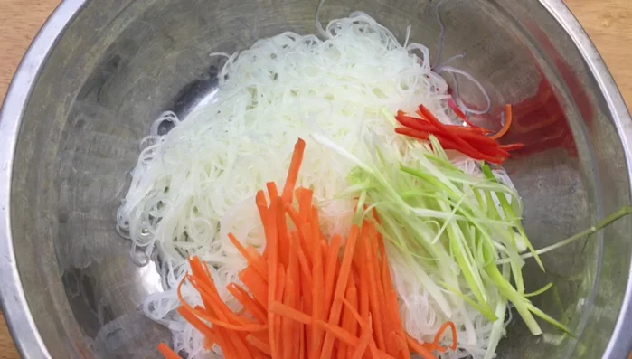 Trộn miến với gà xé, cà rốt, hành tím ngâm, ớt, hành lá, ngò gai, lá chanh, mỡ gà, 1 muỗng cà phê bột canh (hoặc đường, muối, hạt nêm).