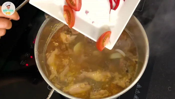 Tắt bếp. Cho cà chua, hành tây, ớt vào nồi lẩu (378.16).