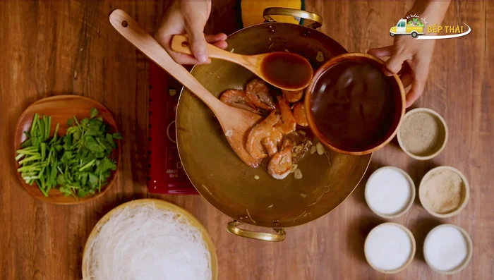 Cho sốt vào xào cùng tôm và miến.