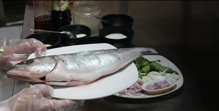 Làm sạch cá, mổ bụng và khứa vài đường trên thân cá. (15.24)