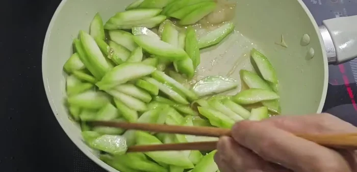 Xào bí xanh: Cho bí xanh vào xào trên lửa lớn đến khi bí chín tới (khoảng 2-3 phút).
