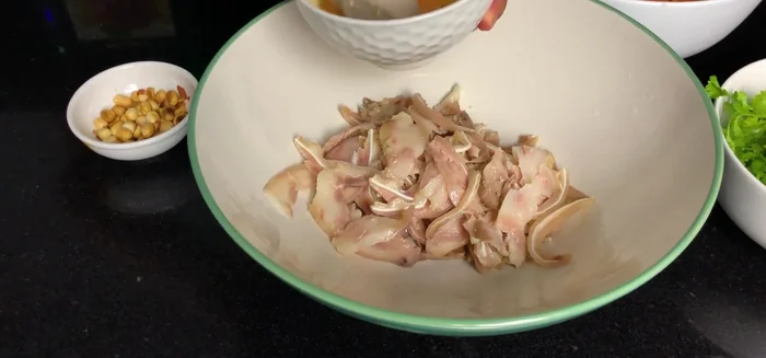Trộn tai heo với nước sốt, tỏi, ớt băm.