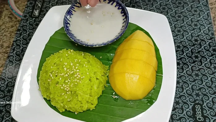 Trình bày xôi ra đĩa, chan nước cốt dừa, rắc mè rang và ăn cùng xoài chín. (383.1)