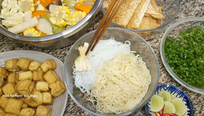 Trộn mì chay với nước dùng, cho thêm đậu hũ chiên, tàu hũ ky lá vào tô.