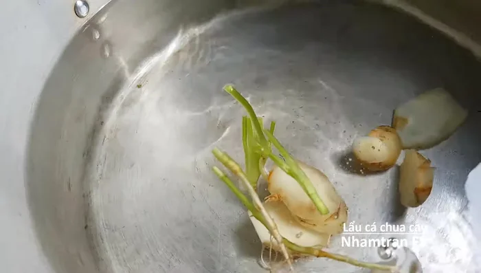 Nấu nước dùng: Cho nước khoảng 3.5 lít vào nồi, thêm sả, gừng, hành tím, tỏi, muối, một nửa trái thơm vào đun sôi. Hớt bọt.