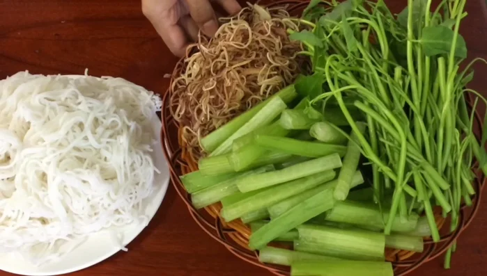 Chuẩn bị rau ăn kèm: bông chuối bào ngâm với muối và chanh, rau muống, rau cần.