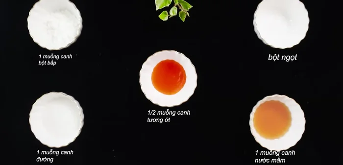 Trộn đều các gia vị (tương ớt, bột bắp, đường, nước mắm, bột ngọt) trong chén cho tan hết.