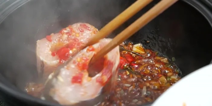 Cho cá vào nồi đất, xếp một lớp ở đáy nồi.