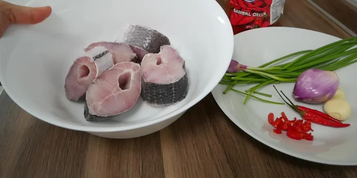 Rửa cá lóc với giấm và muối cho sạch nhớt, cắt khúc (nếu chưa được cắt sẵn).