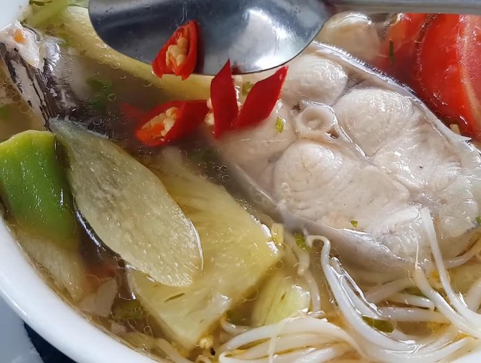 Thêm ớt, rau thơm, tỏi phi vào nồi canh.