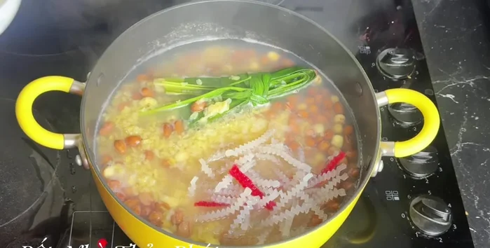 Khi hạt sen mềm, cho bột khoai và bột báng vào, khuấy đều.