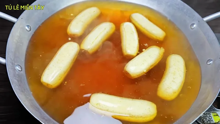 Nấu chuối: Cho chuối vào chảo đường, đun sôi, hạ lửa nhỏ, sên khoảng 1 tiếng.