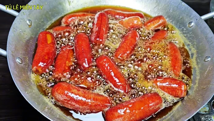 Thêm cơm dừa: Cho cơm dừa non vào, sên thêm 15 phút đến khi nước đường sánh lại.