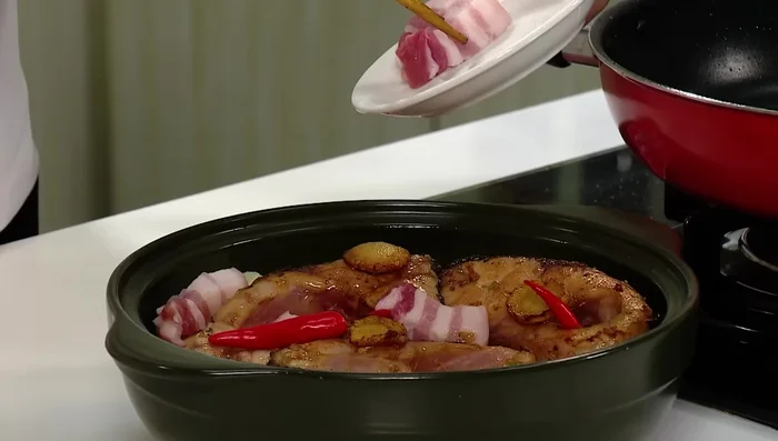 Cho ớt, thịt ba chỉ (đã cắt miếng vừa ăn), nước ướp cá vào nồi.