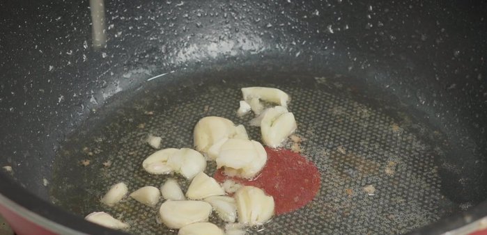 Phi thơm 2/3 số tỏi còn lại, cho bông bí vào xào ở lửa lớn. Đừng vội lật, để bông bí ngấm dầu và tiết nước khoảng 10 giây rồi lật và đảo đều.