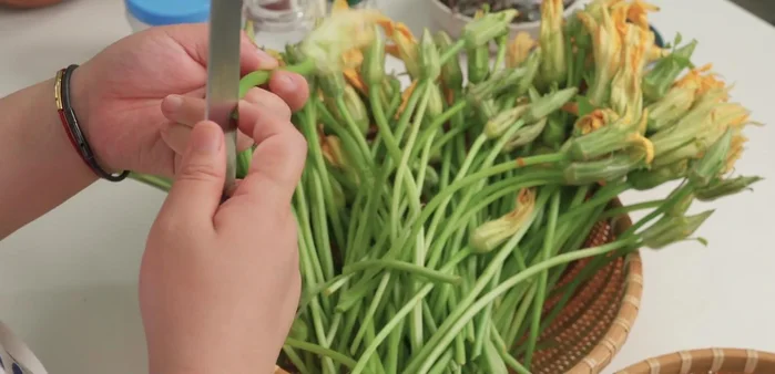 Tước sơ, cắt bỏ phần gốc già của ngọn bông bí, cắt thành khúc dài 6-7cm. Bỏ nhụy bông bí để tránh vị đắng.