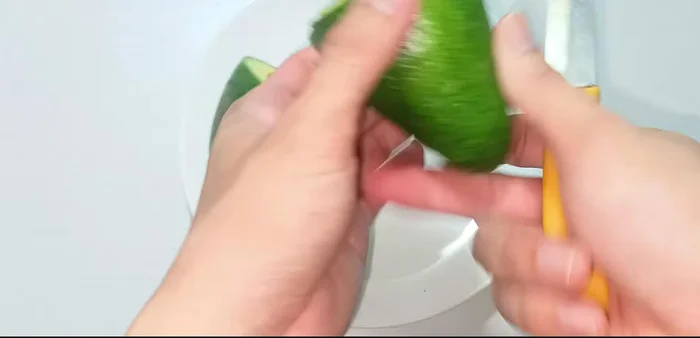 Tách lấy phần cơm bơ, tránh lấy phần vỏ xanh gần hạt, vì sẽ làm sinh tố bị đắng.