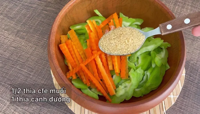 Ướp khổ qua và cà rốt với ½ thìa cà phê muối, 1 thìa canh đường, trộn đều.