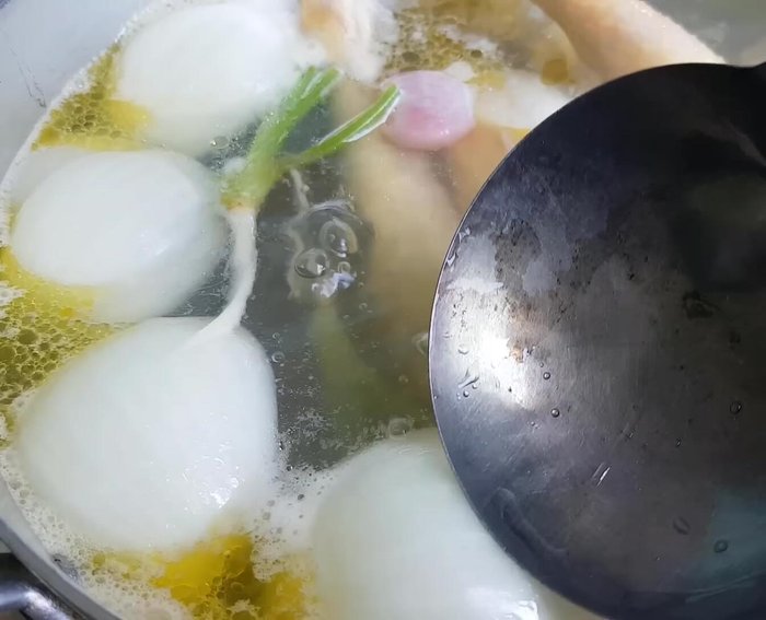 Luộc gà khoảng 20 phút, vớt bọt, trở đều gà để chín.