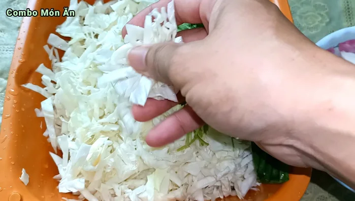 Cắt nhỏ bắp cải thành sợi, rửa sạch và để ráo.