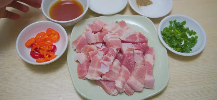Cắt thịt ba chỉ thành từng miếng vừa ăn. (41.399)